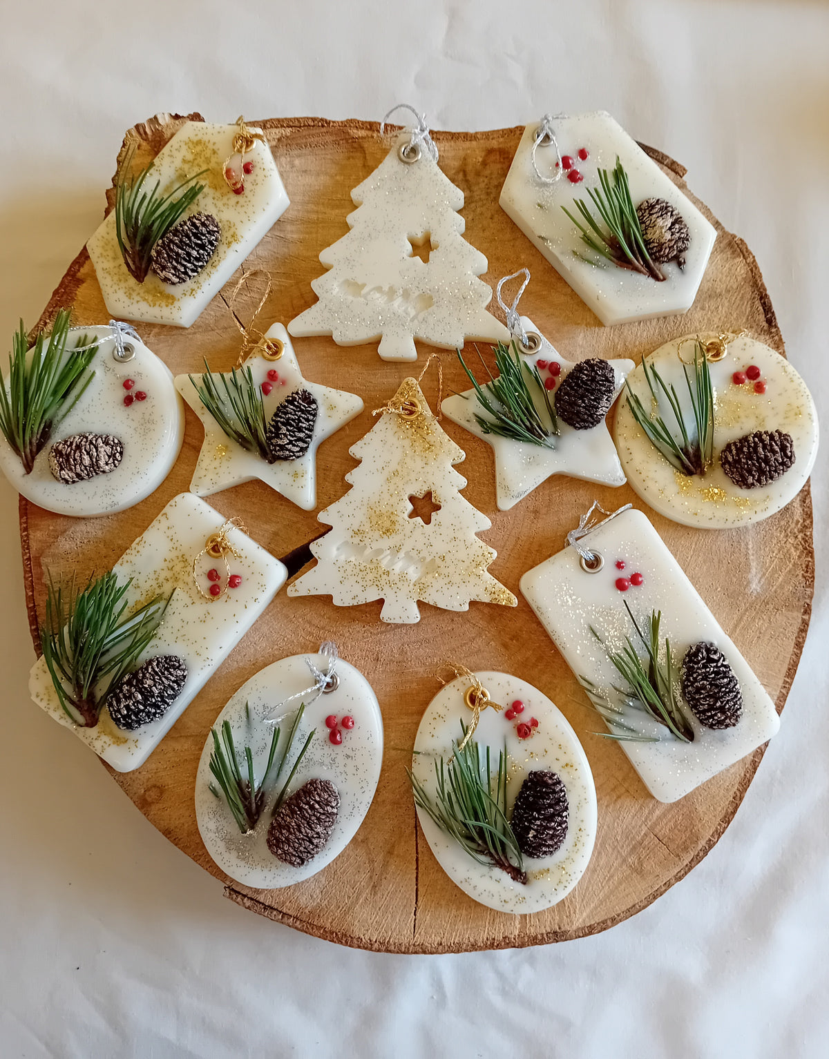 Wooden log slice with variously decorated shaped wax sachets on a log slice background.
